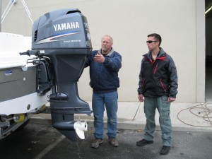 People inspecting outboard moter